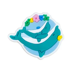 Détail de breloques dauphin bleu en PVC avec fleurs colorées pour décorer des sabots