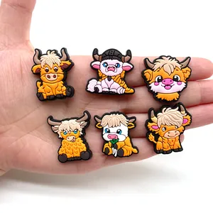Set of 6 cartoon Highland Cow PVC shoe charms for clogs held in palm for scale