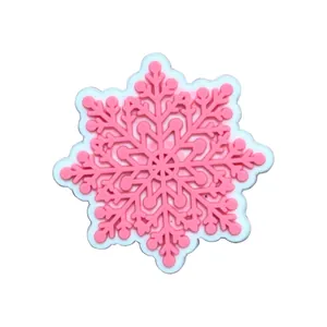 Close-up of pink and white snowflake PVC shoe charms for garden clogs decoration