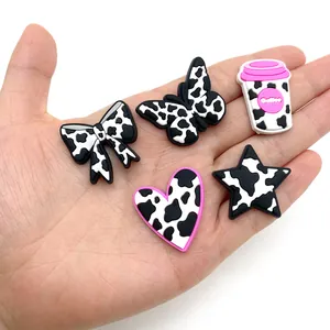 5-piece cartoon cow print PVC shoe charms set featuring heart, bow, and butterfly shapes