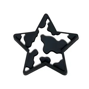 Star shaped PVC shoe charm featuring black and white cow print texture for clogs