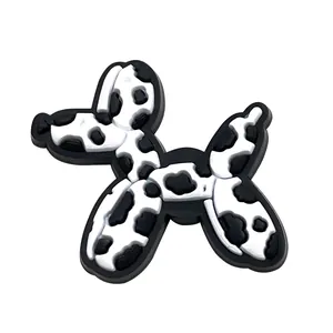 Detailed view of 3D PVC balloon dog shoe charm with black and white cow print patterns