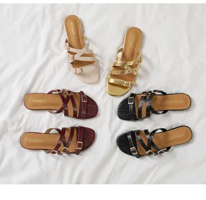 Flat round-toe sandals in cream, gold, burgundy, and black featuring thin cross straps
