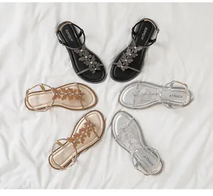 Flat gladiator sandals featuring rhinestone flower details in black, gold, and silver colors