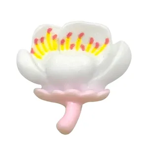 Macro detail of cartoon 3D resin flower charm with white petals and pink base for shoes