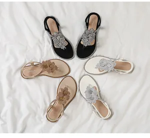 Overhead view of flat beach sandals with sparkling flower rhinestone detail in three colors