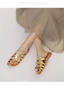 Detail view of gold strappy flat sandals with adjustable buckles on a model