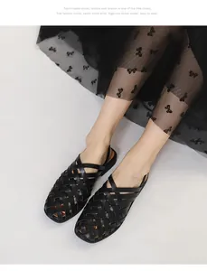 Primer plano de sandalias de cuero trenzado negro llevadas por modelo en ambiente elegante