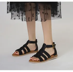 Detailansicht der schwarzen Riemchensandalen mit goldenen Schnallen und Korksohle