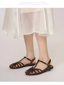 Detailansicht dunkelbrauner geflochtener Metallsandalen mit verstellbarem Riemenverschluss