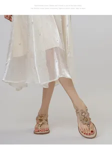 Detail of rhinestone flowers on champagne flat sandals with crystal trim and gladiator straps