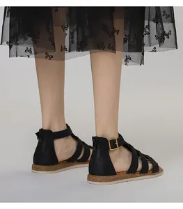 Detail von schwarzen flachen Gladiator Sandalen mit Korksohle und goldener Schnalle
