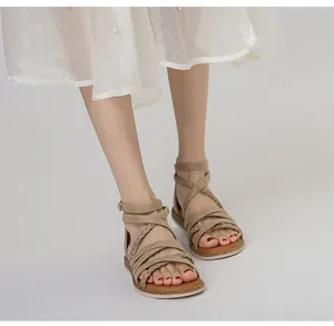 Detail der gewebten Riemen und Kork-Fußbett bei beigen römischen flachen Sandalen