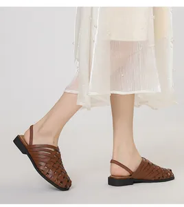 Detalle de sandalias de cuero trenzado a mano marrón oscuro con diseño hueco