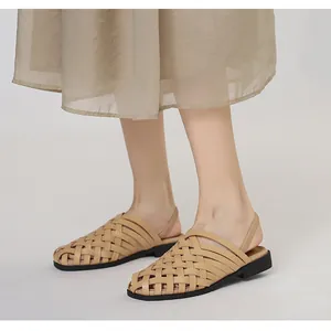 Primer plano de sandalias romanas tejidas a mano en color beige con tira elástica