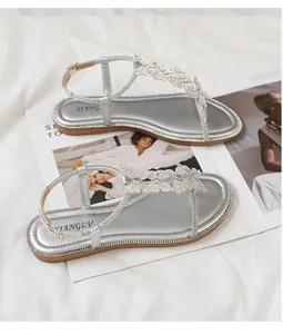 Detailed view of silver flat sandals with three sparkling rhinestone butterfly ornaments