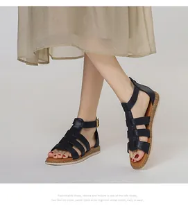 Detail von schwarzen Gladiator-Sandalen mit Kork-Zwischensohle und goldener Schließe