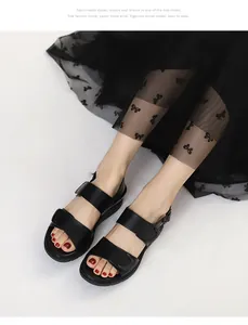 Detail von schwarzen Plateau-Sandalen mit verstellbaren Riemen und einem schwarzen Tüllrock