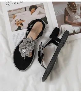 Detail of flat sandals with rhinestone flower ornaments and sparkling crystal edges