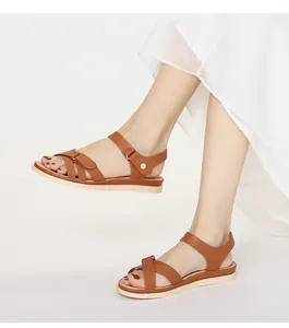 Detail von braunen Leder-Sandalen mit verstellbaren Knöchelriemen und goldener Schnalle