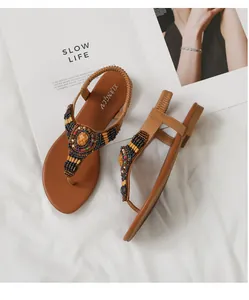 Λεπτομέρεια από boho σανδάλια με χάντρες, έθνικ σχέδια και ελαστικό λουράκι στη φτέρνα