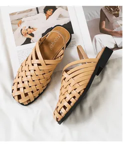 Detalle de sandalias romanas beige tejidas a mano sobre fondo de revista de moda