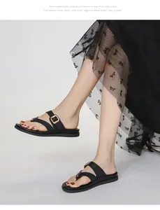 Detalle de chanclas negras con correas de cuero y elegantes hebillas doradas