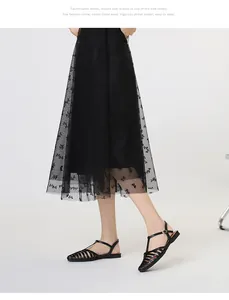 Detail of black woven hollow-out sandals paired with butterfly print mesh skirt