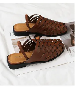 Detalle de sandalias de cuero marrón tejidas a mano con diseño calado y banda elástica