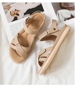Detailansicht beige flache Sandalen mit goldener Metallschnalle und Klettverschluss