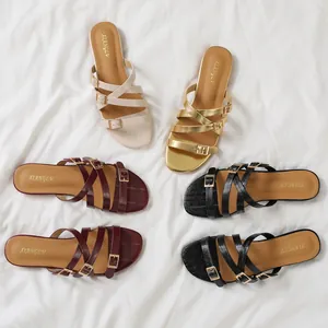 Flat slide sandals for women with multi-strap crisscross design and golden metal buckles