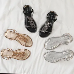 Flat Roman sandals with T-strap rhinestone bow in black, gold, and silver colors