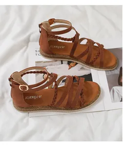 Nahaufnahme brauner flacher Websandalen mit Wildlederriemen und Vintage-Metallschnalle