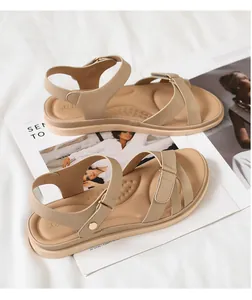 Details flacher beige Römersandalen mit Schnallenverschluss auf Modezeitschriften-Hintergrund