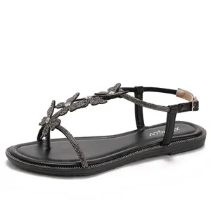 Elegant black flat T-strap sandals featuring sparkling rhinestone butterfly embellishments