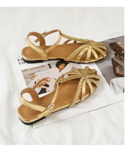 Detailansicht goldener geflochtener Römersandalen mit verstellbarer Knöchelschnalle