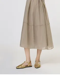 Detail of woven metallic gold strappy sandals with square toe and adjustable T-bar buckle