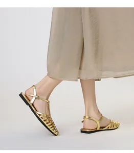 Side view of golden woven strappy sandals with square toe and slim ankle buckle strap