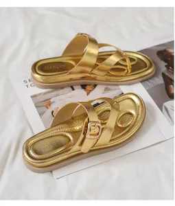 Primer plano de chanclas doradas con hebilla ajustable y plantilla antideslizante