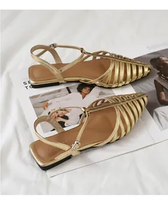 Detailed view of golden woven strap fisherman sandals with adjustable ankle buckle strap