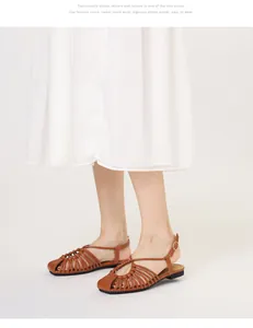 Macro detail of brown woven leather huarache sandals with adjustable gold buckle