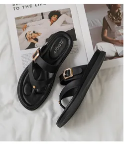 Detalle de sandalias de dedo negras con hebilla metálica y cuero mate de calidad