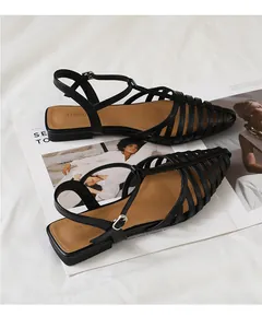 Macro detail of the woven leather cage design and buckle strap on women's black sandals
