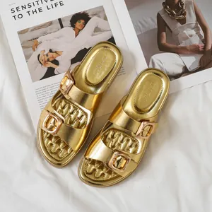 Sandali dorati metallizzati da donna con doppia fibbia e suola spessa su sfondo bianco