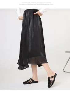 Detail of woven black flat sandals featuring a gold buckle with a satin pleated skirt