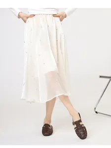 Detail of cream pearlescent midi skirt with pearl embellishments and A-line cut