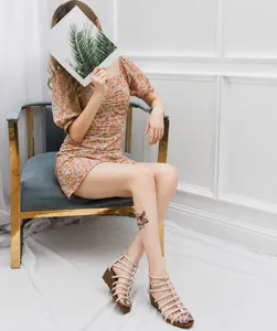 Detail van beige sandalen met sleehak met fijne bandjes en elegante gouden gespen