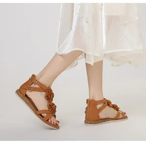 Detail of brown Roman flat sandals featuring 3D floral accents and rear zipper closure