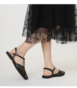 Detail von schwarzen Retro-Sandalen mit goldenen Nieten und verstellbarem Riemchen
