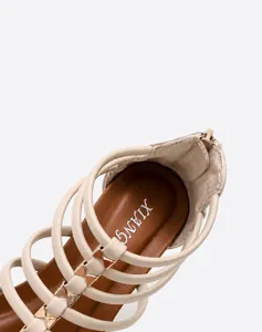 Detail van de comfortabele binnenzool en gouden gesp op beige sleehak sandalen